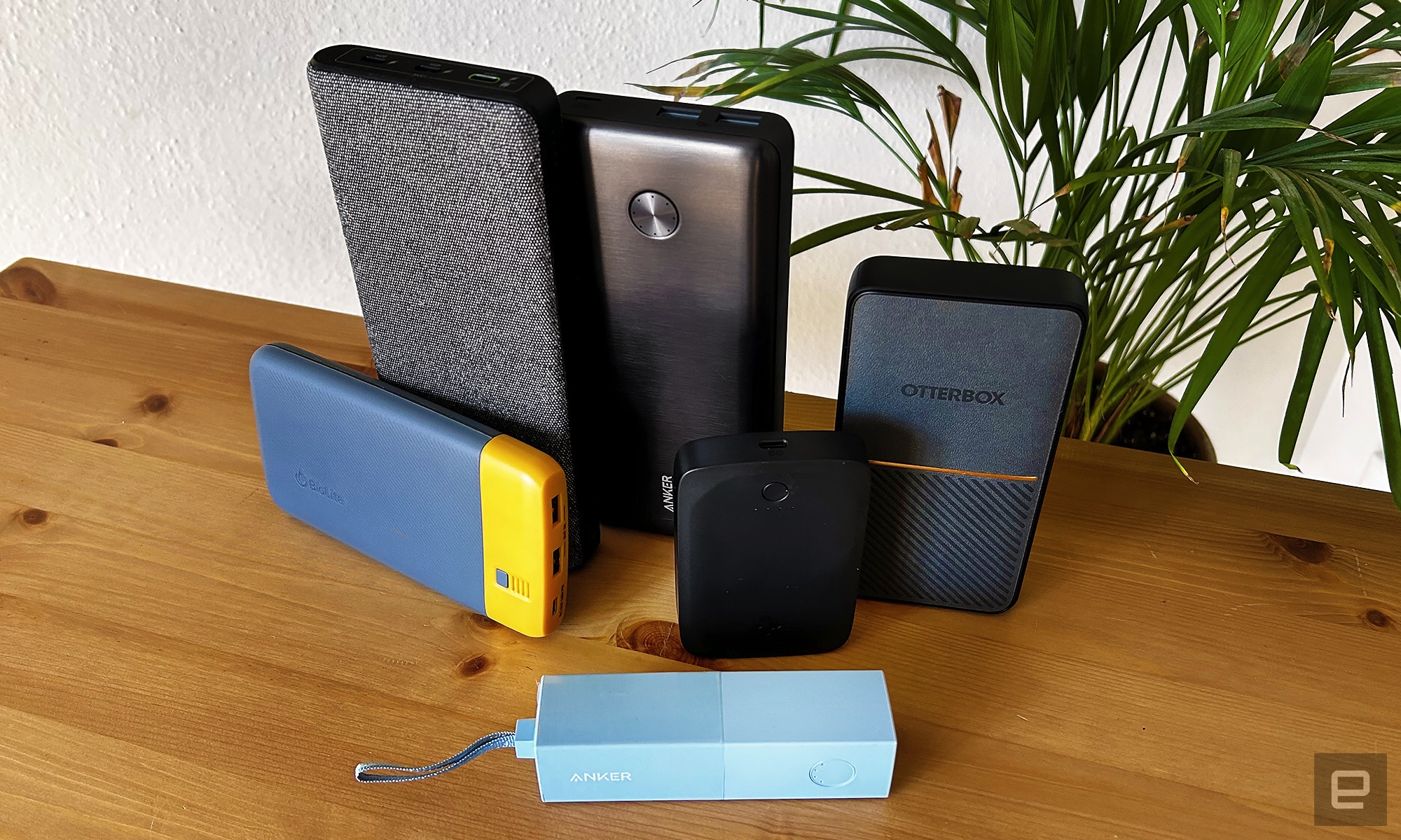 The six winning power banks arranged on a wooden table with a houseplant in the background | DeviceDaily.com